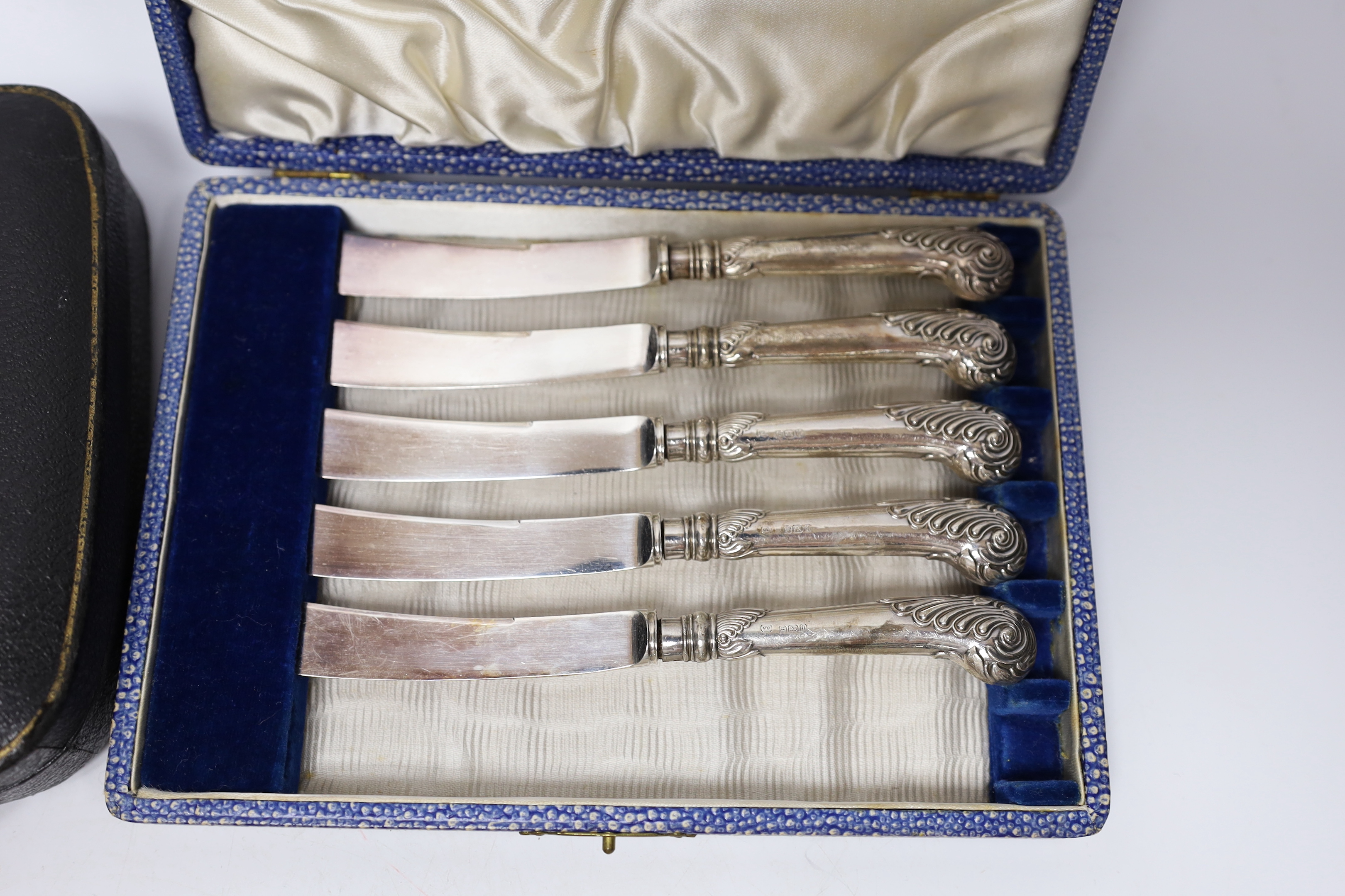 Six pairs of German Art Nouveau 800 standard white metal handled dessert eaters and two cased sets of six silver handled tea knives(one knife missing).